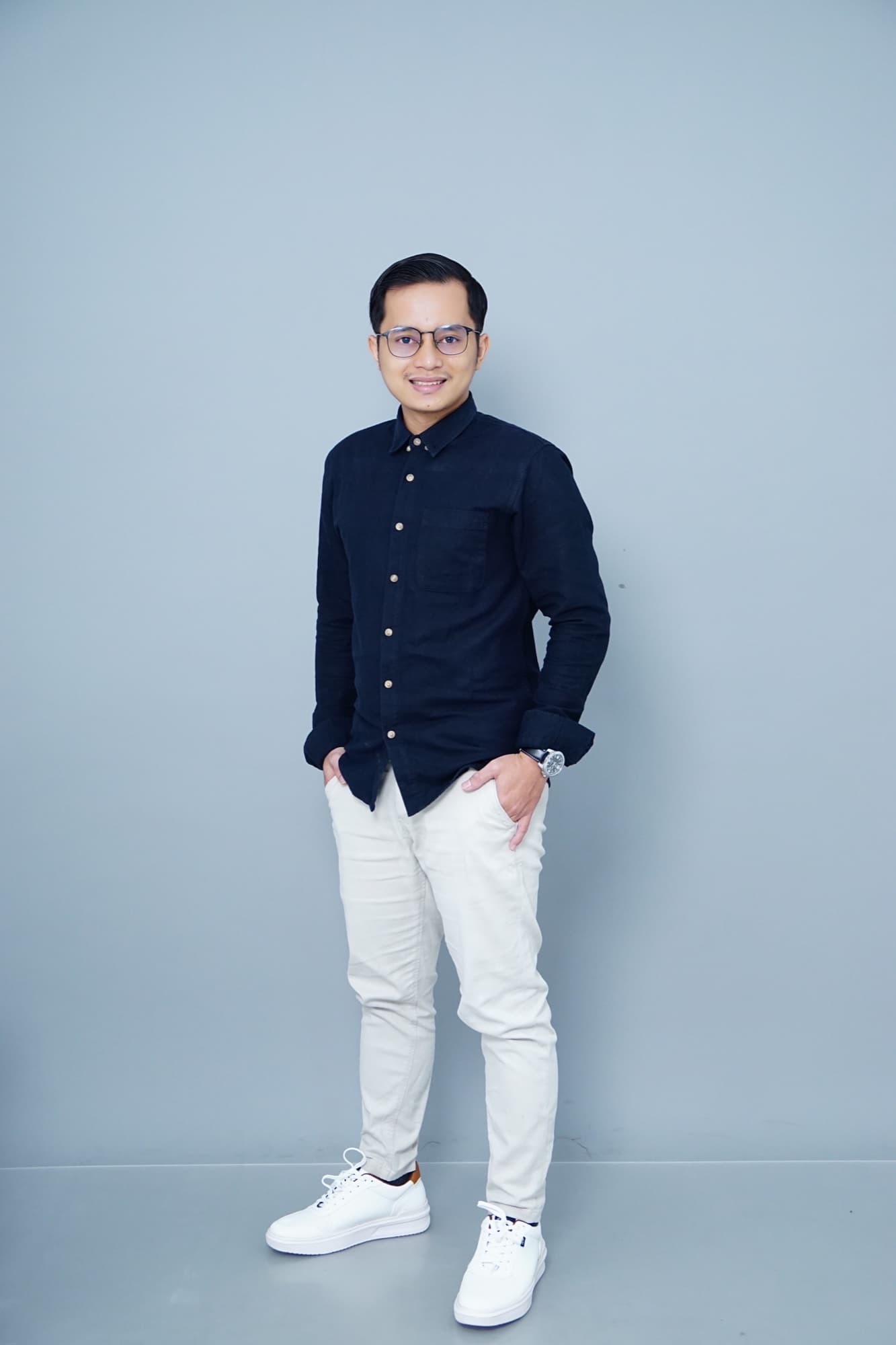 Hilmi H. in a navy shirt and glasses